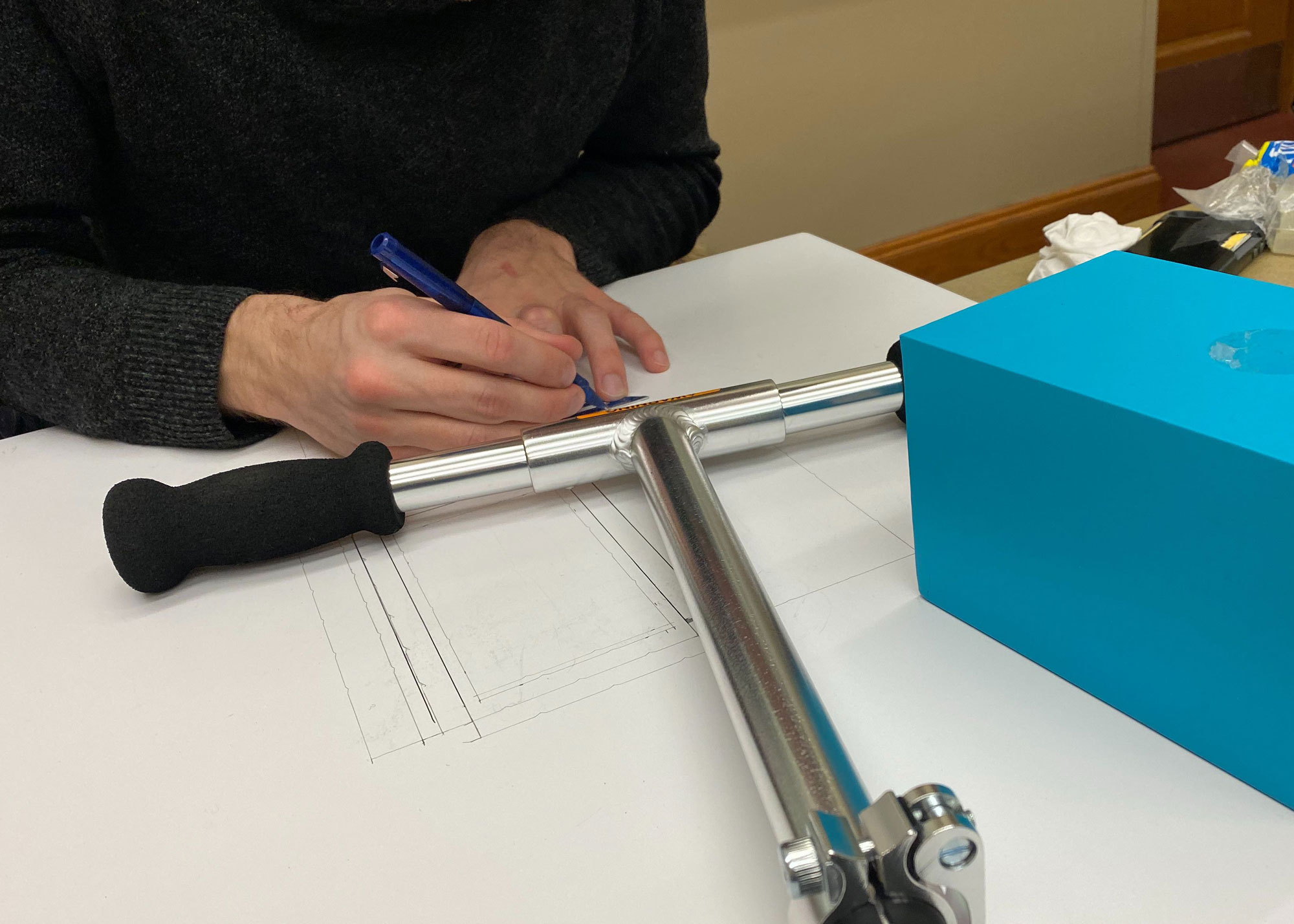 Cameron building the prototype out of foam core using scooter handlebars as a guide