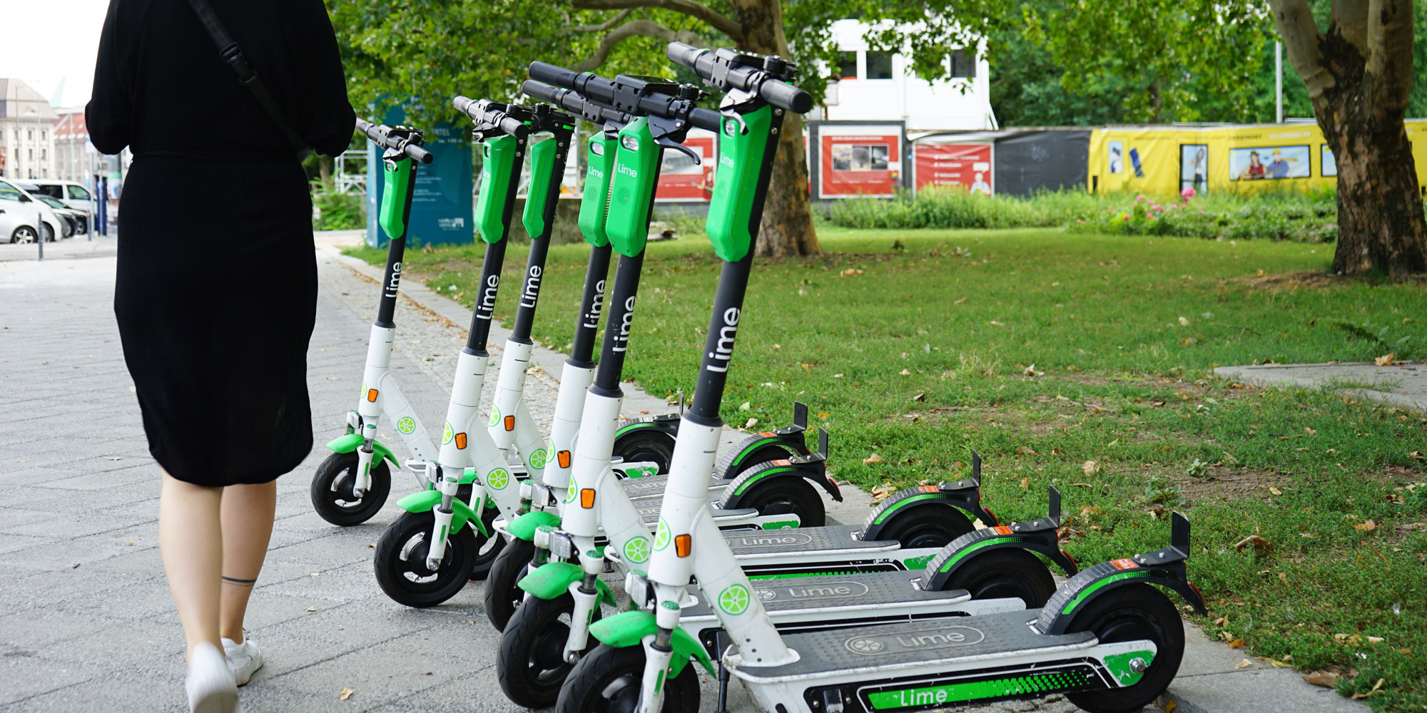 lime brand rental scooters parked on an urban sidewalk